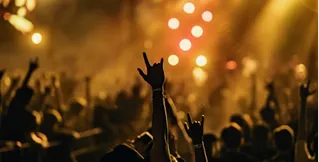 Large concert audience enjoying a professional touring stage production with lighting effects